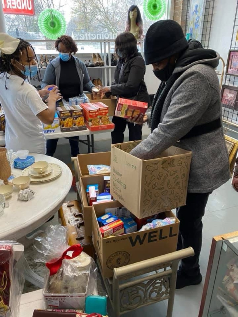 Volunteers pack cardboard boxes with food for neighborhood families