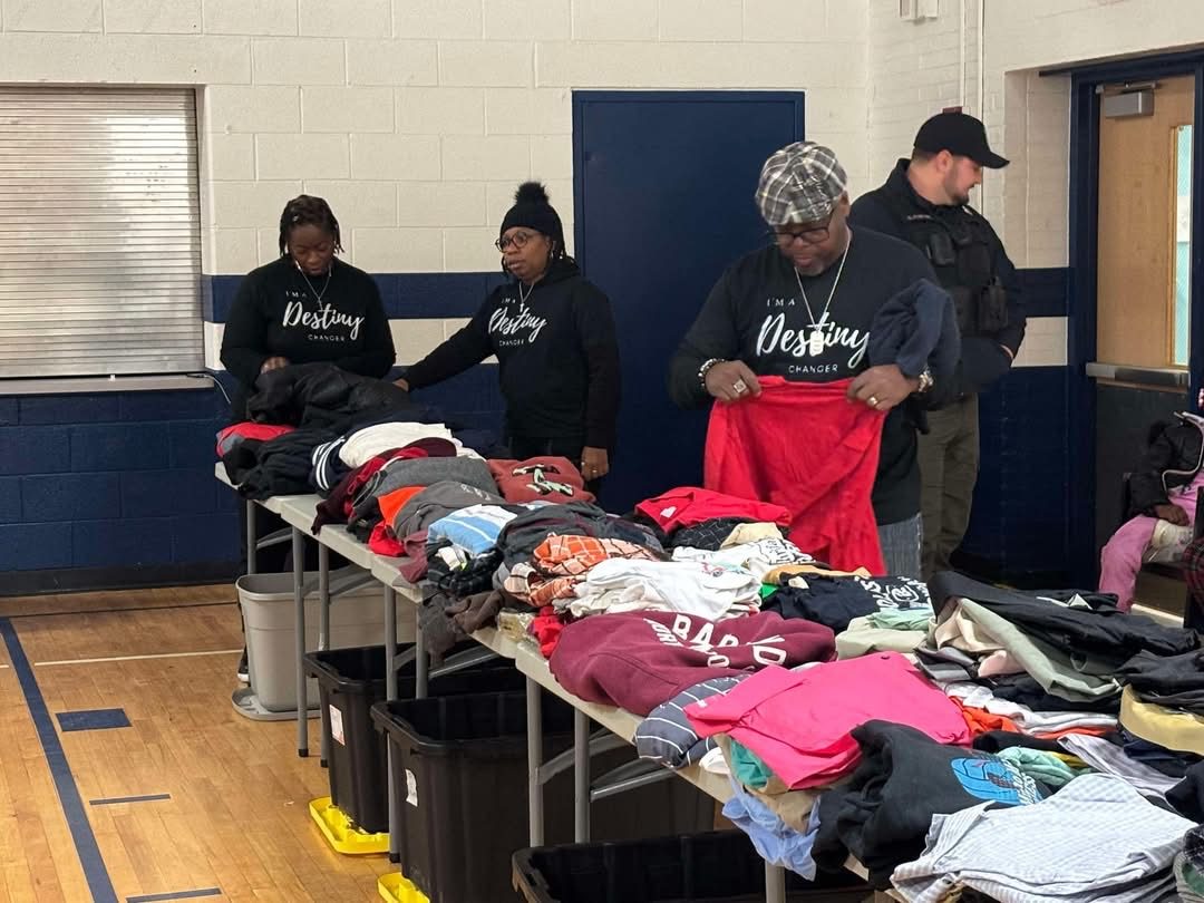 Volunteers wearing Destiny Changer shirts sort donated clothing at a community clothing drive
