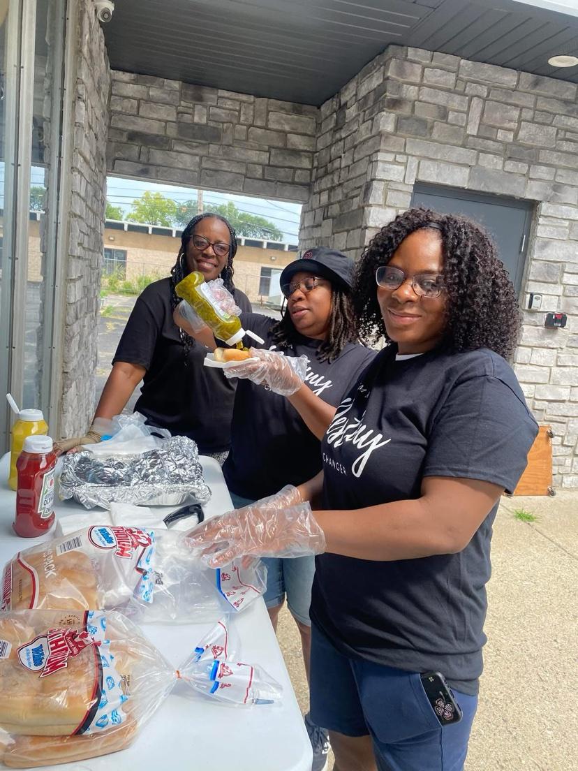 Volunteers in Destiny Changer shirts serving hot dogs