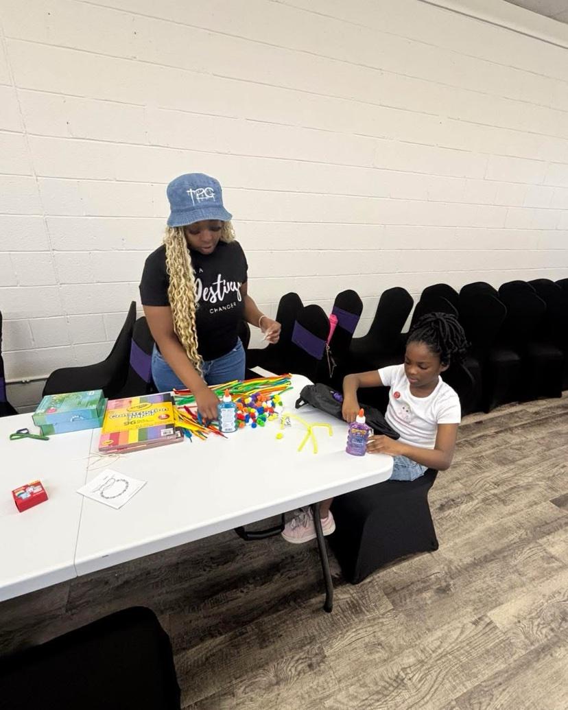 A volunteer and a child doing crafts at a table