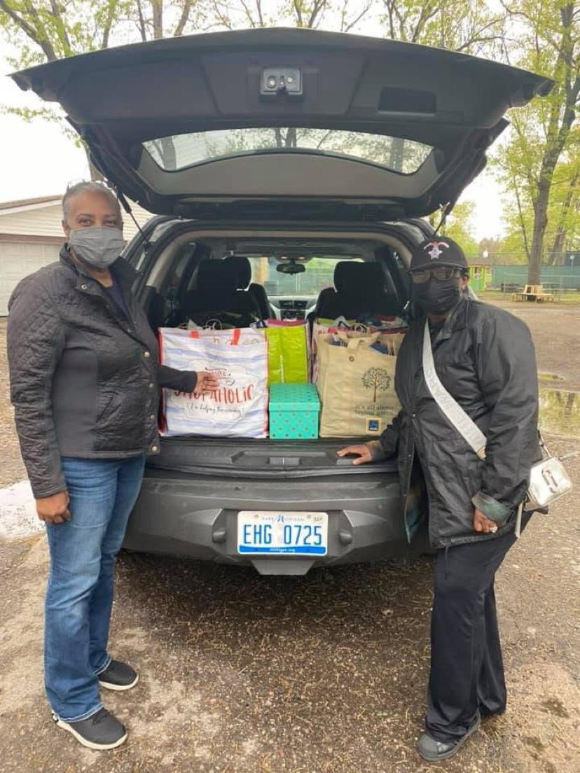 Two volunteers loading gift bags into an SUV