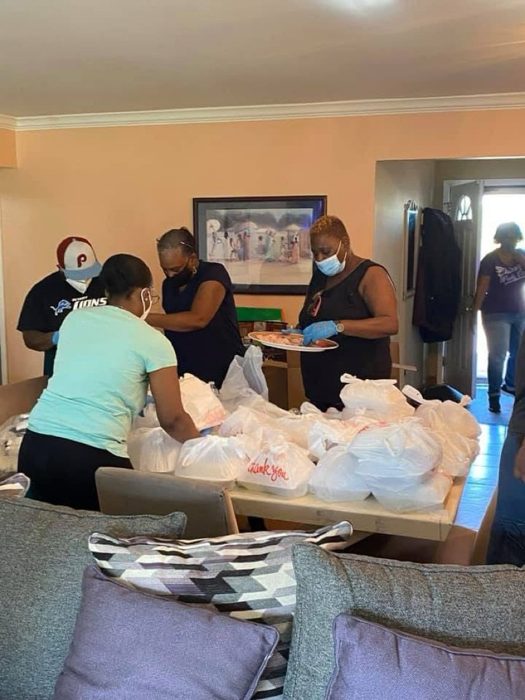 Volunteers packing bagged meals for neighbors.
