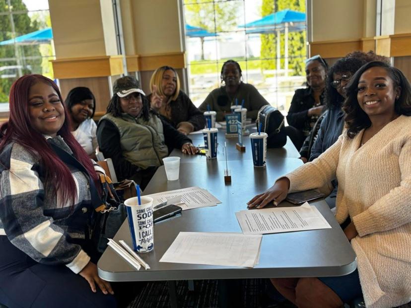A group of women around a restaurant table with papers