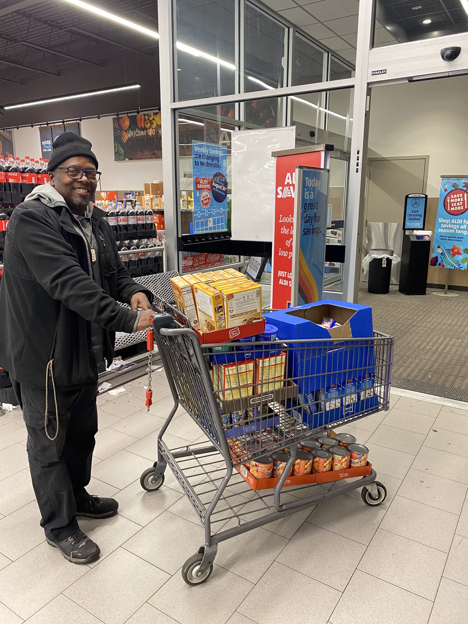 A volunteer with a cart of food-drive groceries